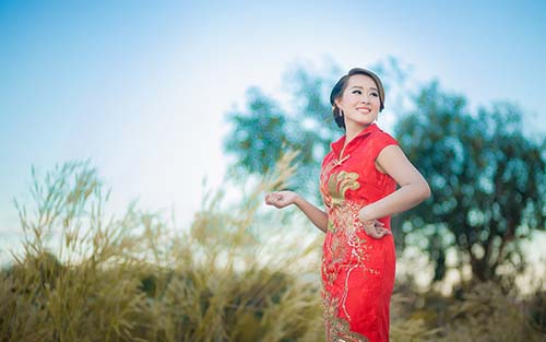 A Chinese woman from Shenzhen China in a traditional Chinese dress posing for a photo.