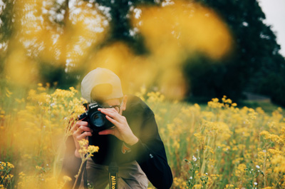 Man with a camera in a flower field.