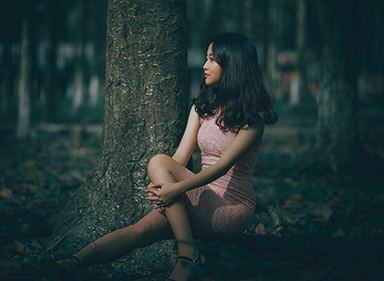 A young Chinese girl sitting under the tree.