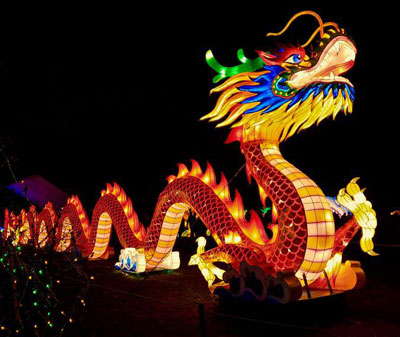 A replica of a dragon lit up with colorful lights