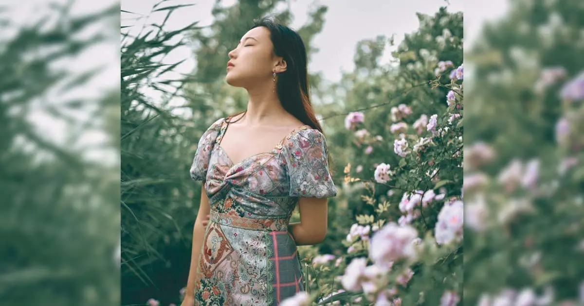 A photo of a Chinese woman amidst flowers